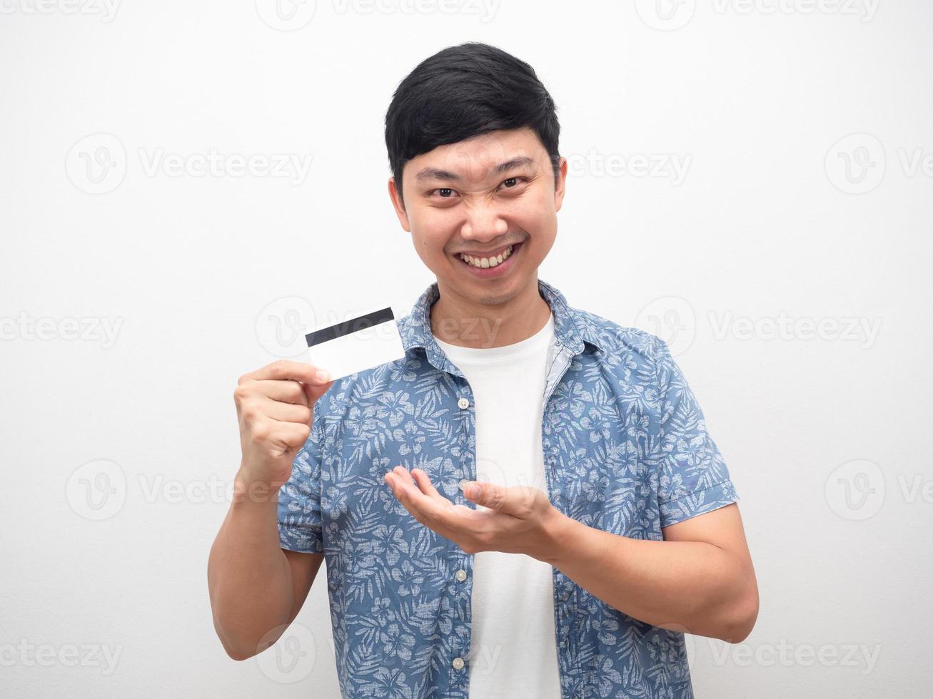 hombre camisa azul que muestra la tarjeta de crédito en la mano sonriendo feliz foto