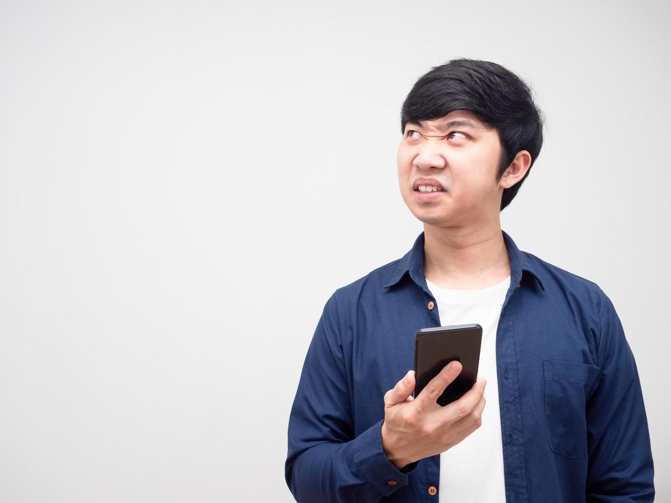 Man holding mobile phone feeling angry looking at copy space white isolated background photo