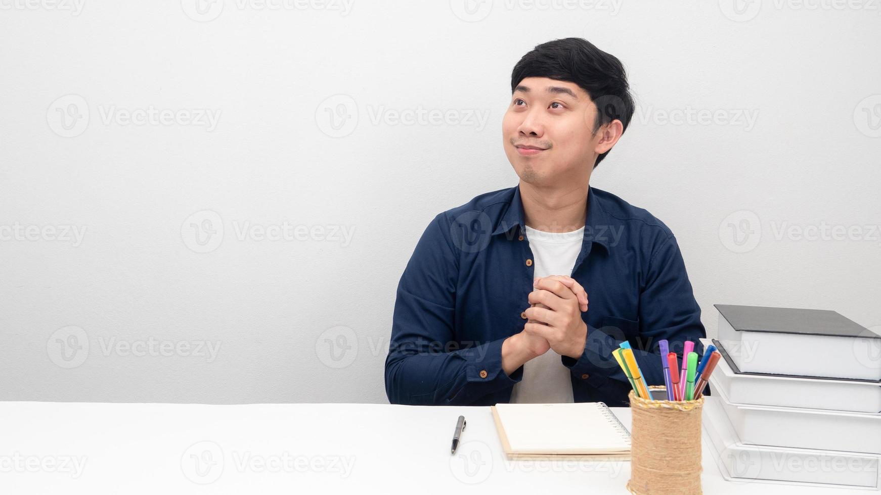 Asian man sitting at the desk happy emotion looking at copy space photo