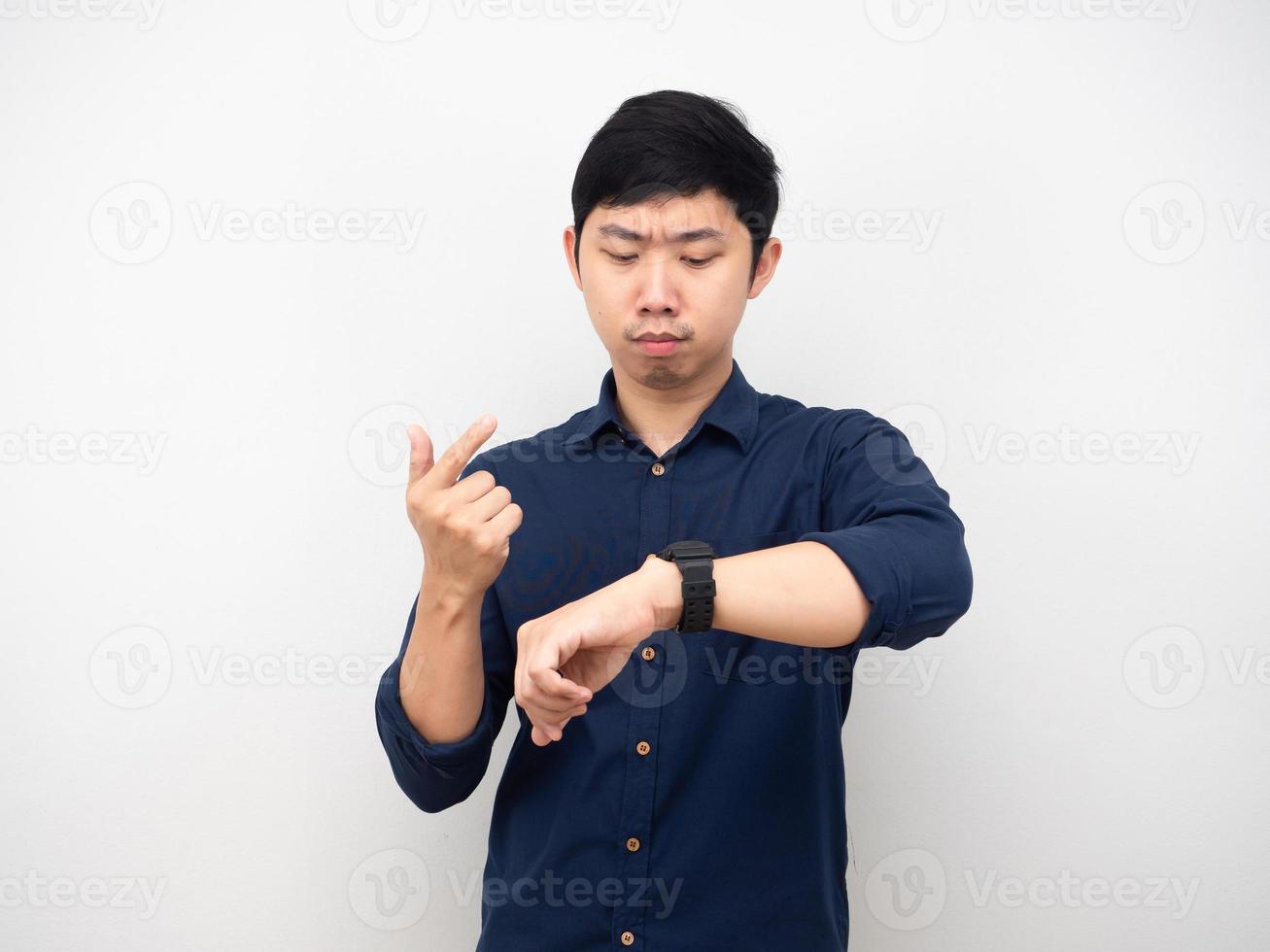 Asian man looking at his watch and counting finger serious emotion photo