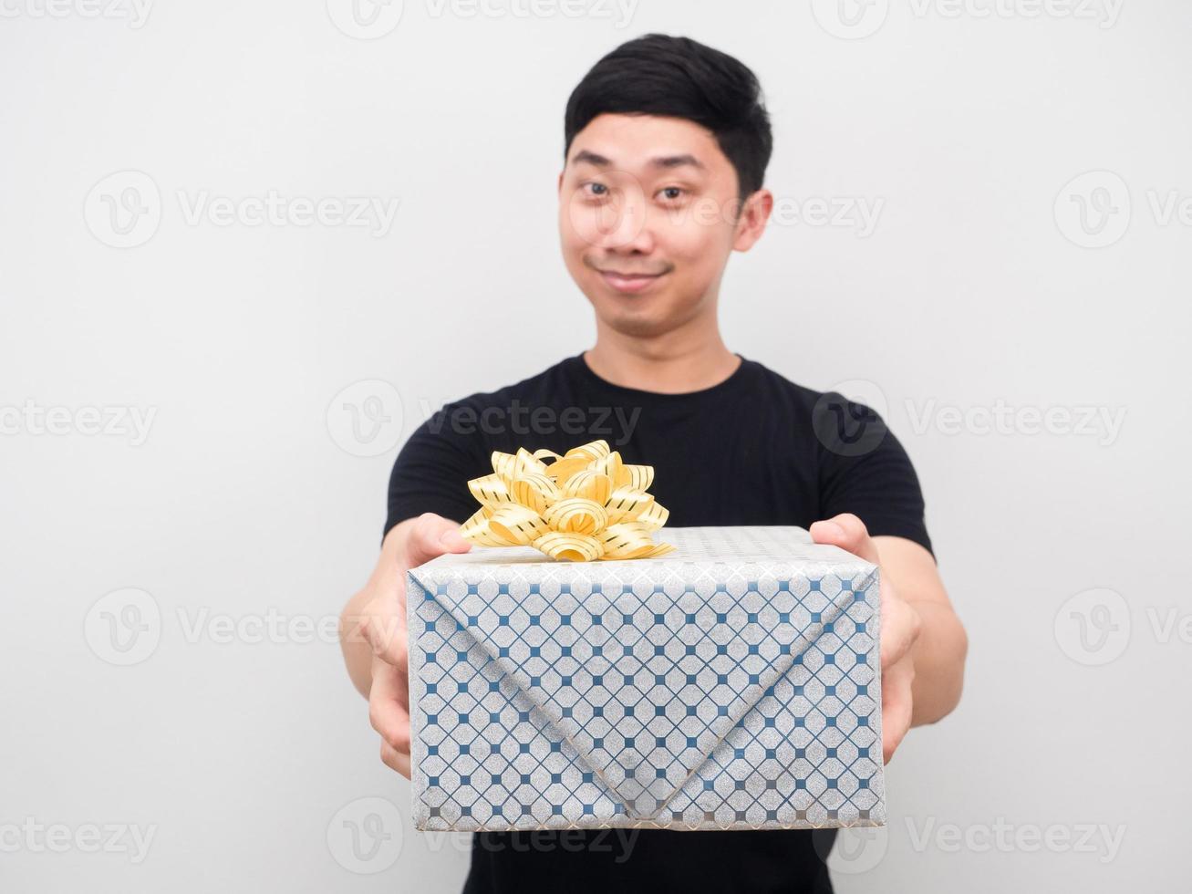 Asian man smiling and giving gift box to you celebration concept photo