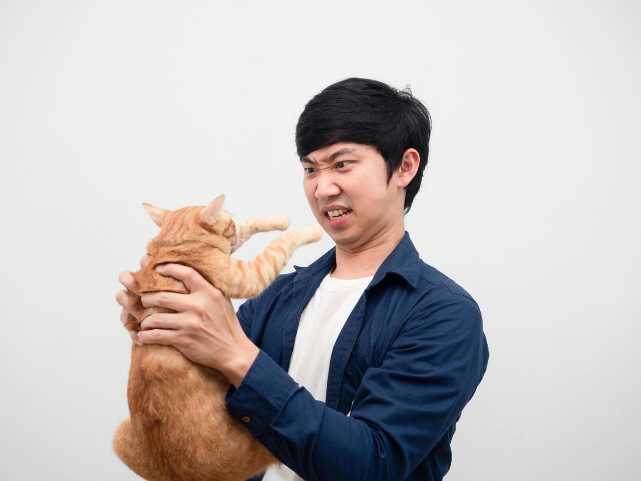 Man feeling angry looking at cat in hand feeling unhappy white background photo