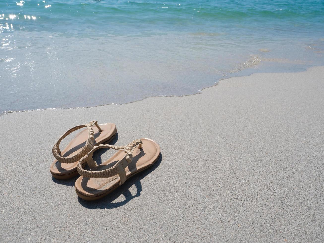 Woman shoe on the beach and blue ocean in natural copy space photo