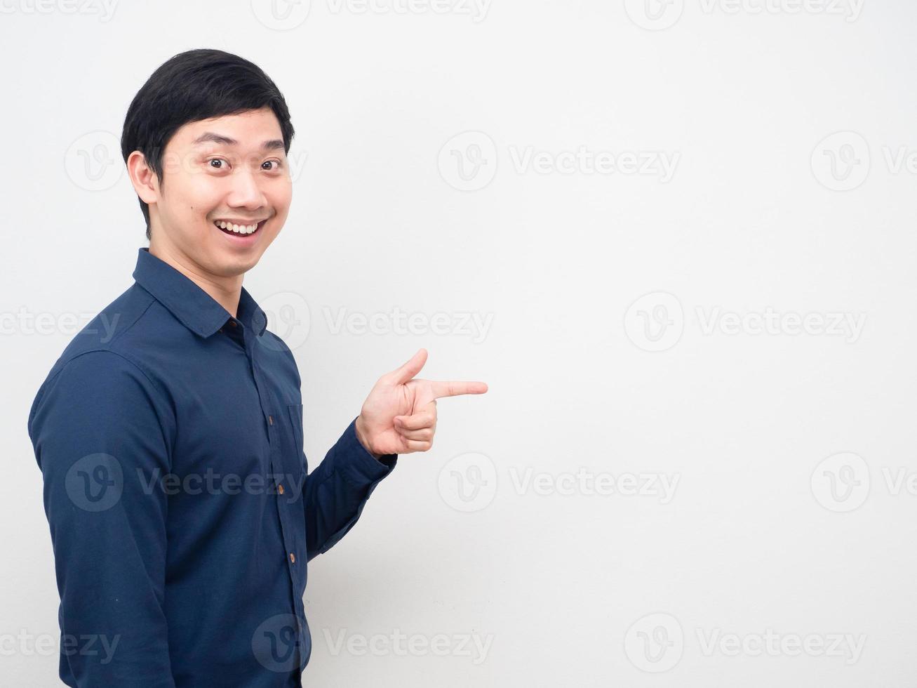 Asian man happy smile point finger at copy space photo