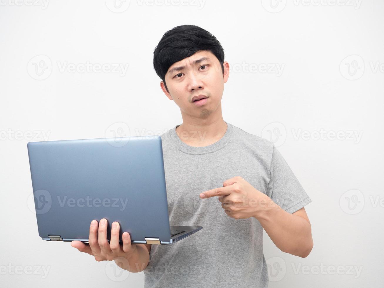 hombre camisa gris señalar con el dedo en la computadora portátil en la mano emoción grave foto