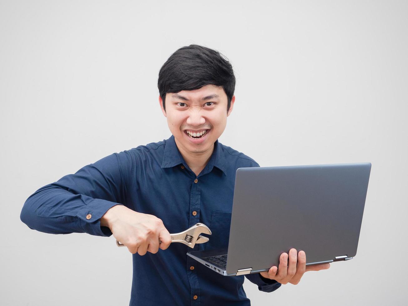 Asian man holding adjustable wrench fixed laptop in his hand confident face portrait on white background photo