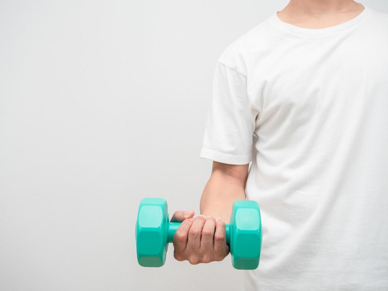 hombre sujetando dumbbell verde clolor fondo blanco crop shot copia espacio foto