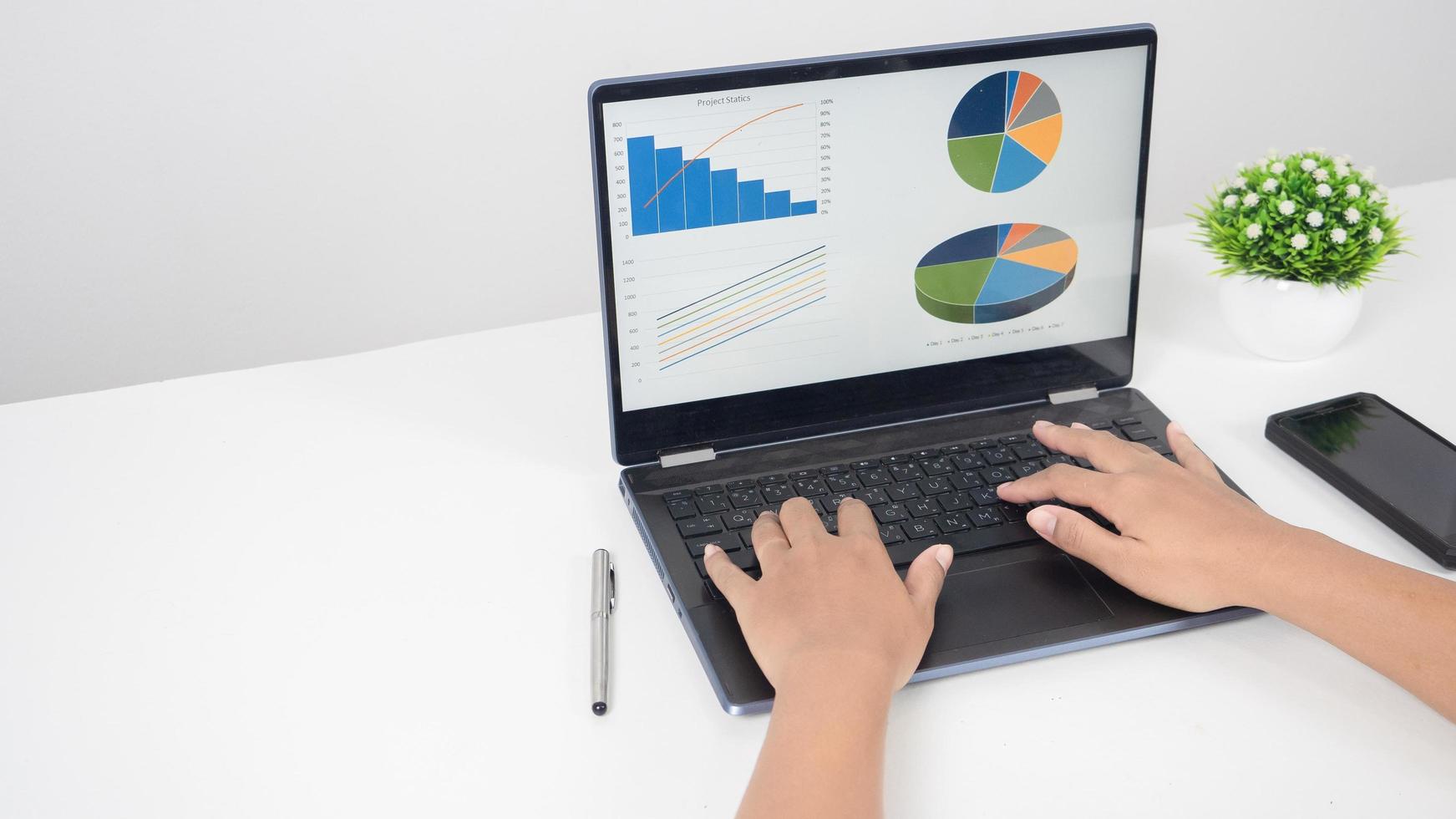 Hand using laptop charts graphs business at screen on the table copy space photo