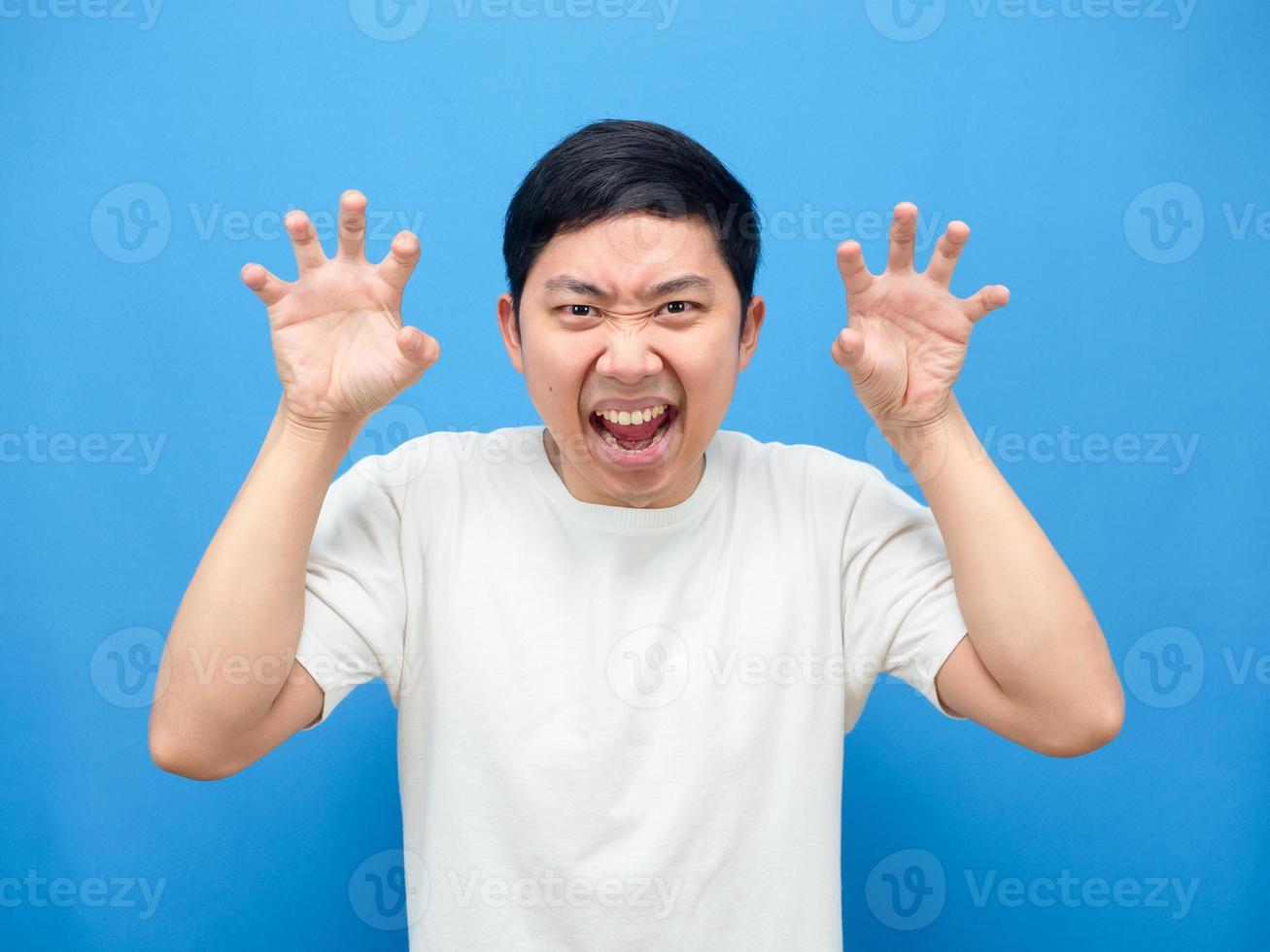 Man gesture scared at you,Asian man hand up gesture horror blue background photo