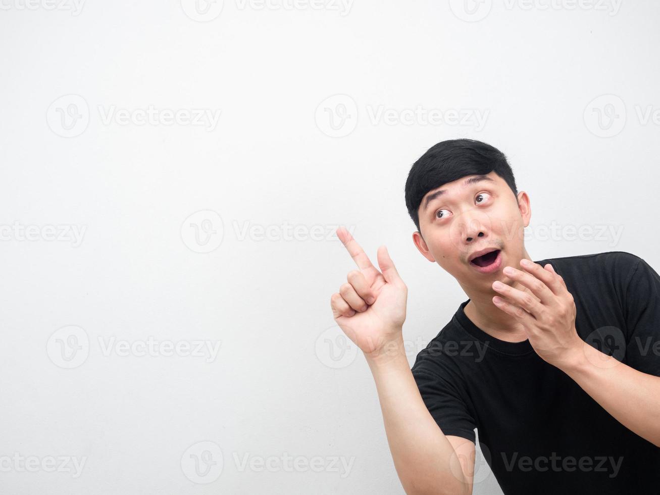 Asian man amazed emotion point finger at copy space photo