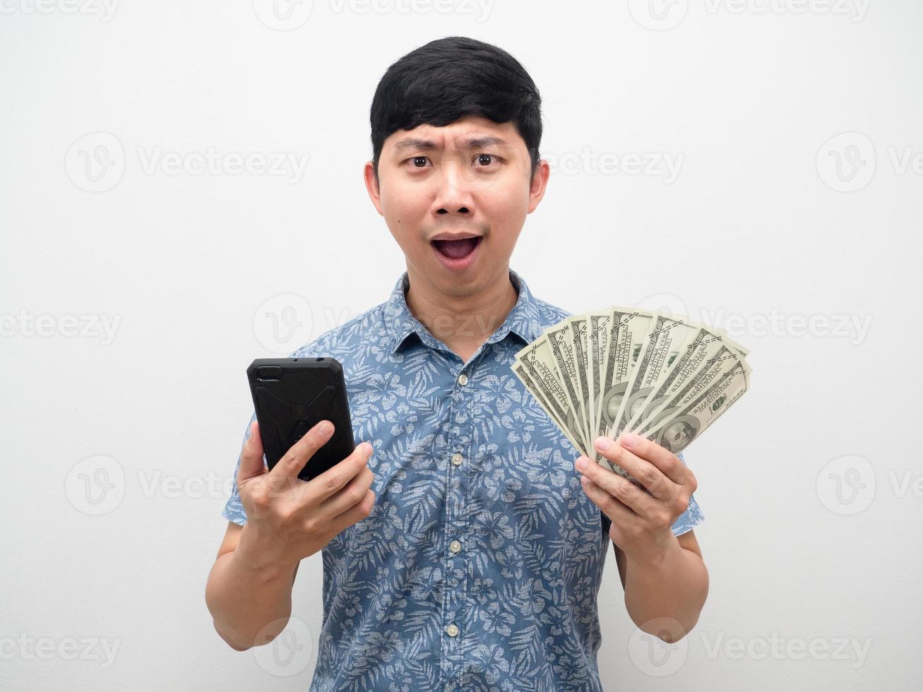 el hombre se siente emocionado sosteniendo un teléfono móvil con mucho dinero foto