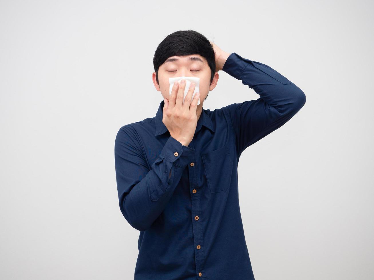 Sick man feeling sick and headache touch his head holding tissue paper at face on white background photo
