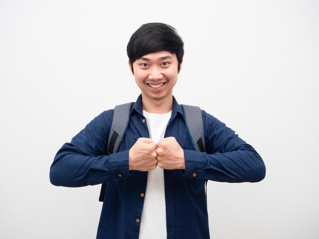 Young man impact fist smile face with backpack portrait white background photo