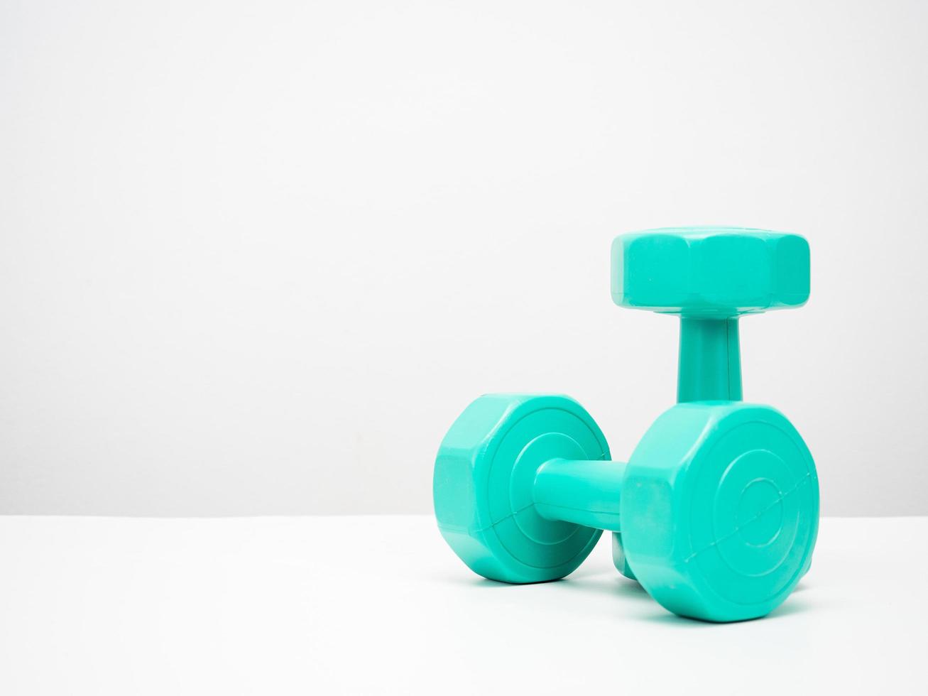 Dumbbell green color on the table white background copy space photo