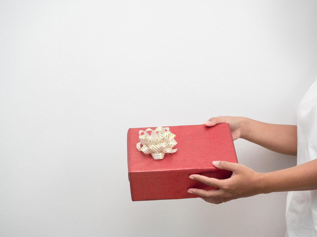 Woman hand holding red gift box on white background copy space photo