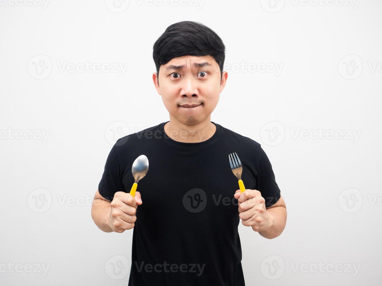 hombre asiático sosteniendo una cuchara sintiéndose muy hambriento foto