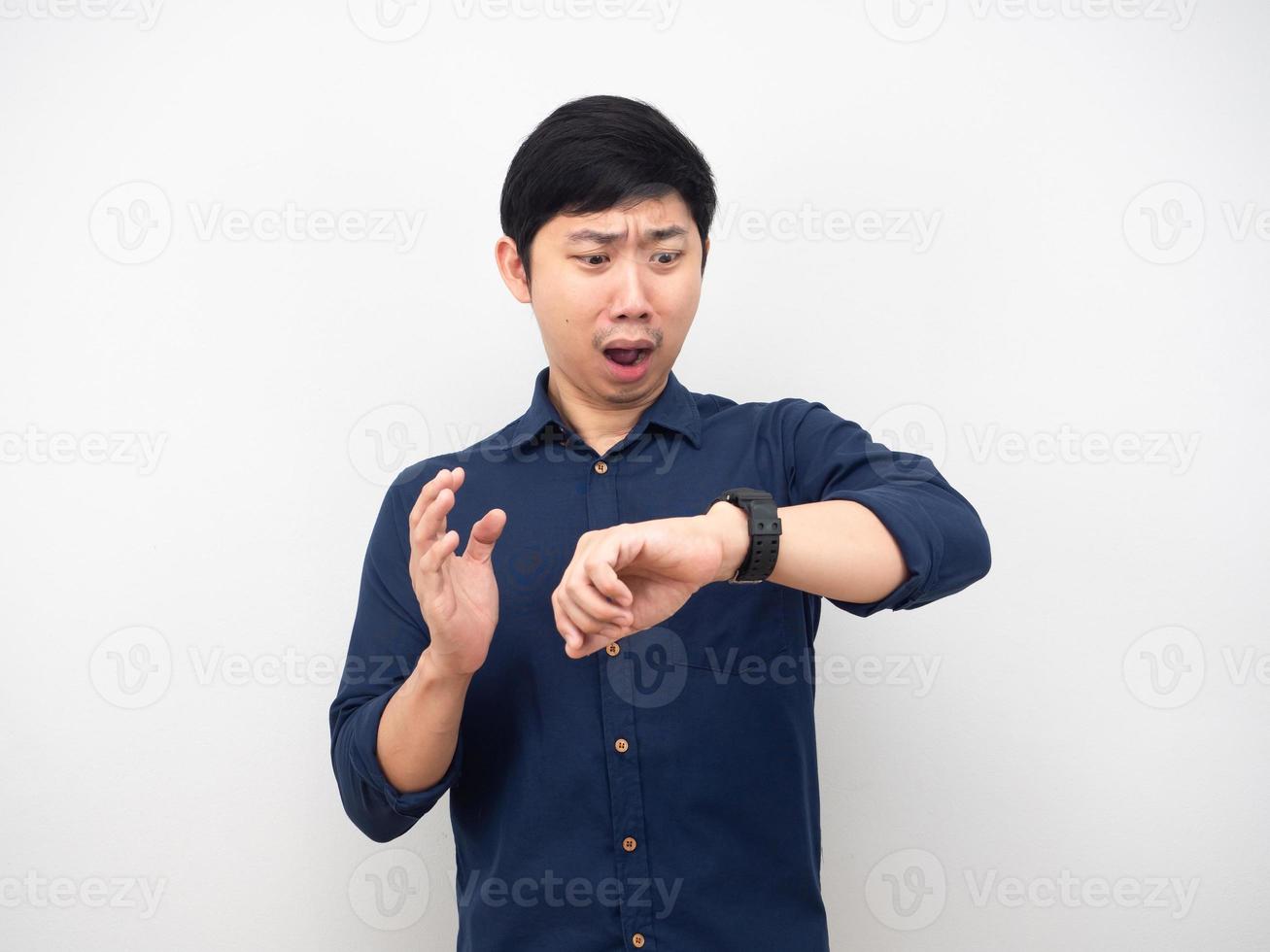 Asian man looking at his watch and feeling shocked time late concept photo