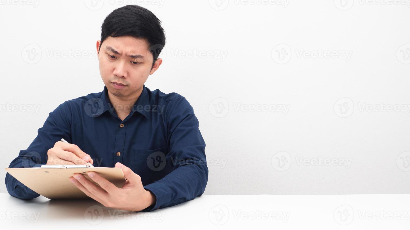 Man serious writing pen on document board on the table copy space photo