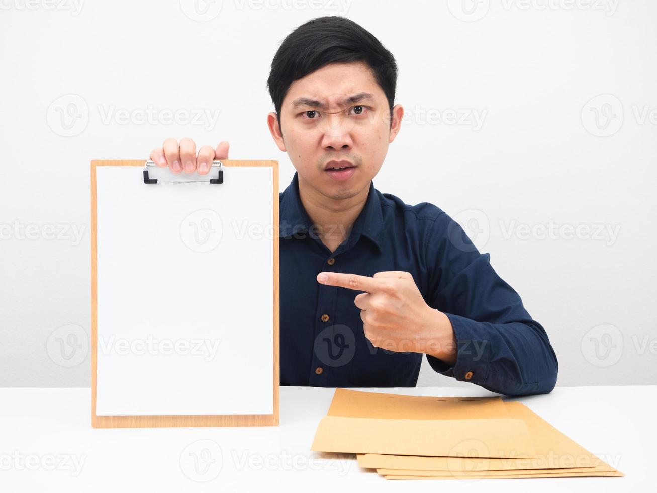 Businessman point finger at blank document board in hand with serious face emotion on the table photo