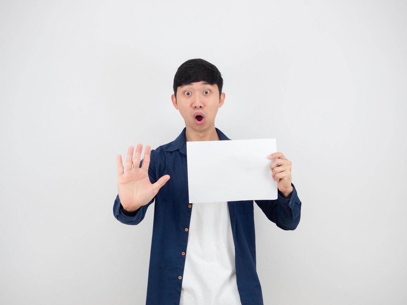 Asian man holding blank sheet and show hand up say no serious face on white isolated background, photo