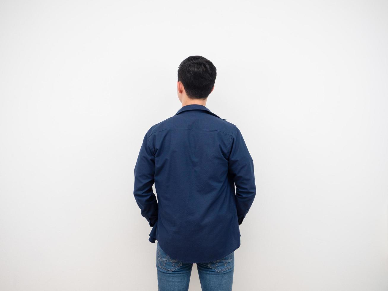 Handsome man back view in jean suit standing at studio white background photo