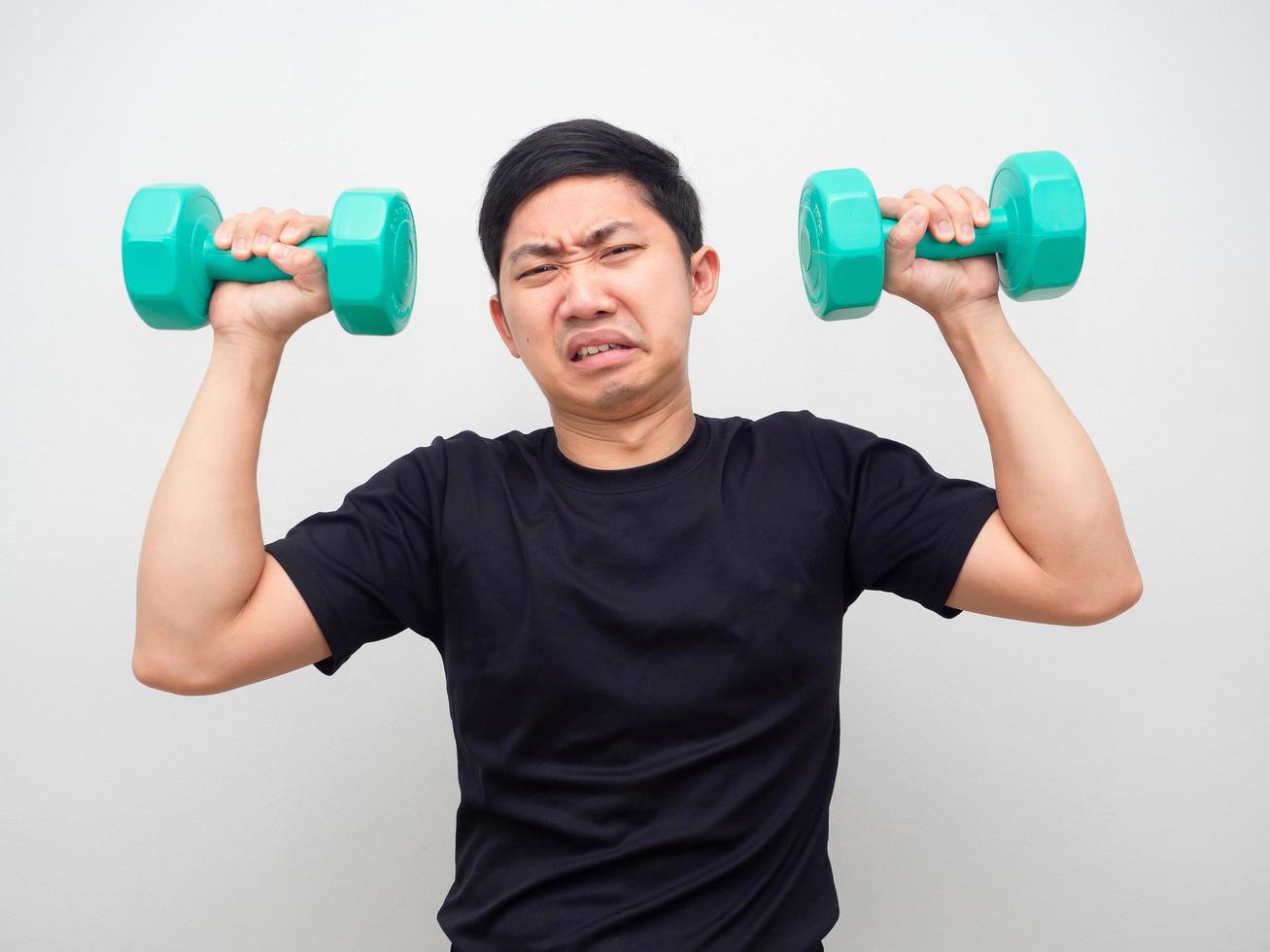 Asian man holding drumbbell feeling heavy for workout photo