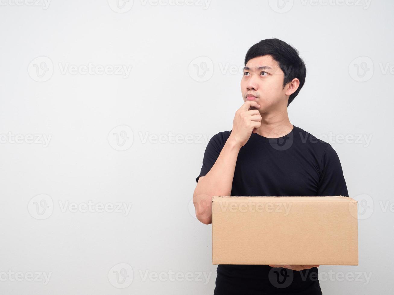 Man black shirt holding parcel box looking at copy space and thinking something photo
