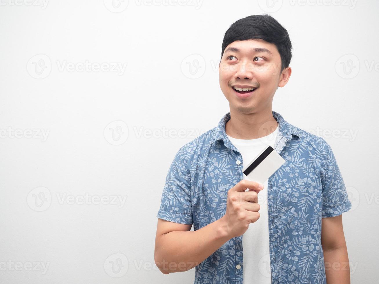 Asian man blue shirt holding credit card and looking at copy space photo