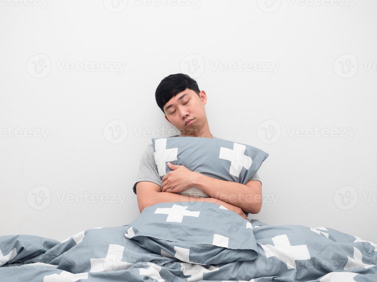 Asian man hugging pillow sleep in bedroom photo
