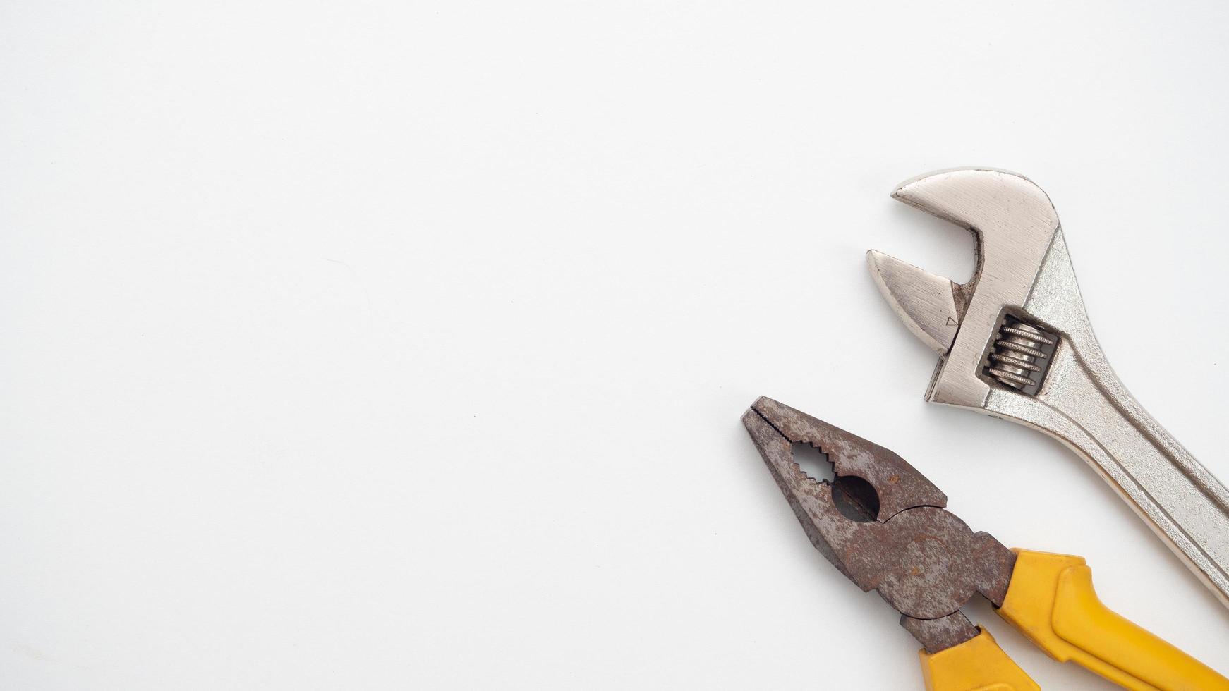 Close up adjustable wrench and pliers on white background top view copy space photo