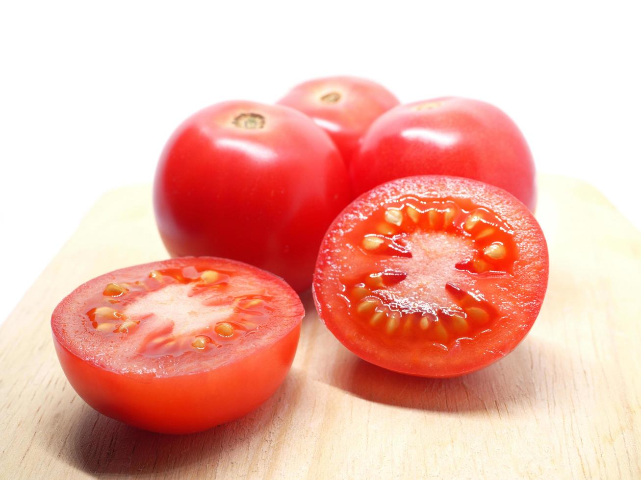 Closeup detail freshness plum tomato cut slice on chopping board nature light shadow on white isolated photo