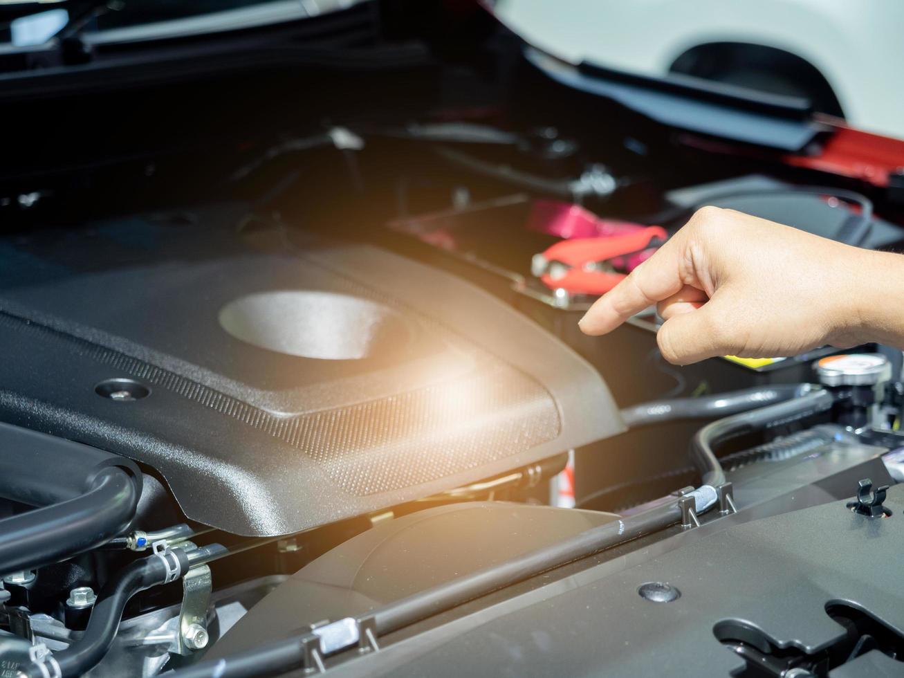 Hand point finger at new engine interioir the new car with light flare photo