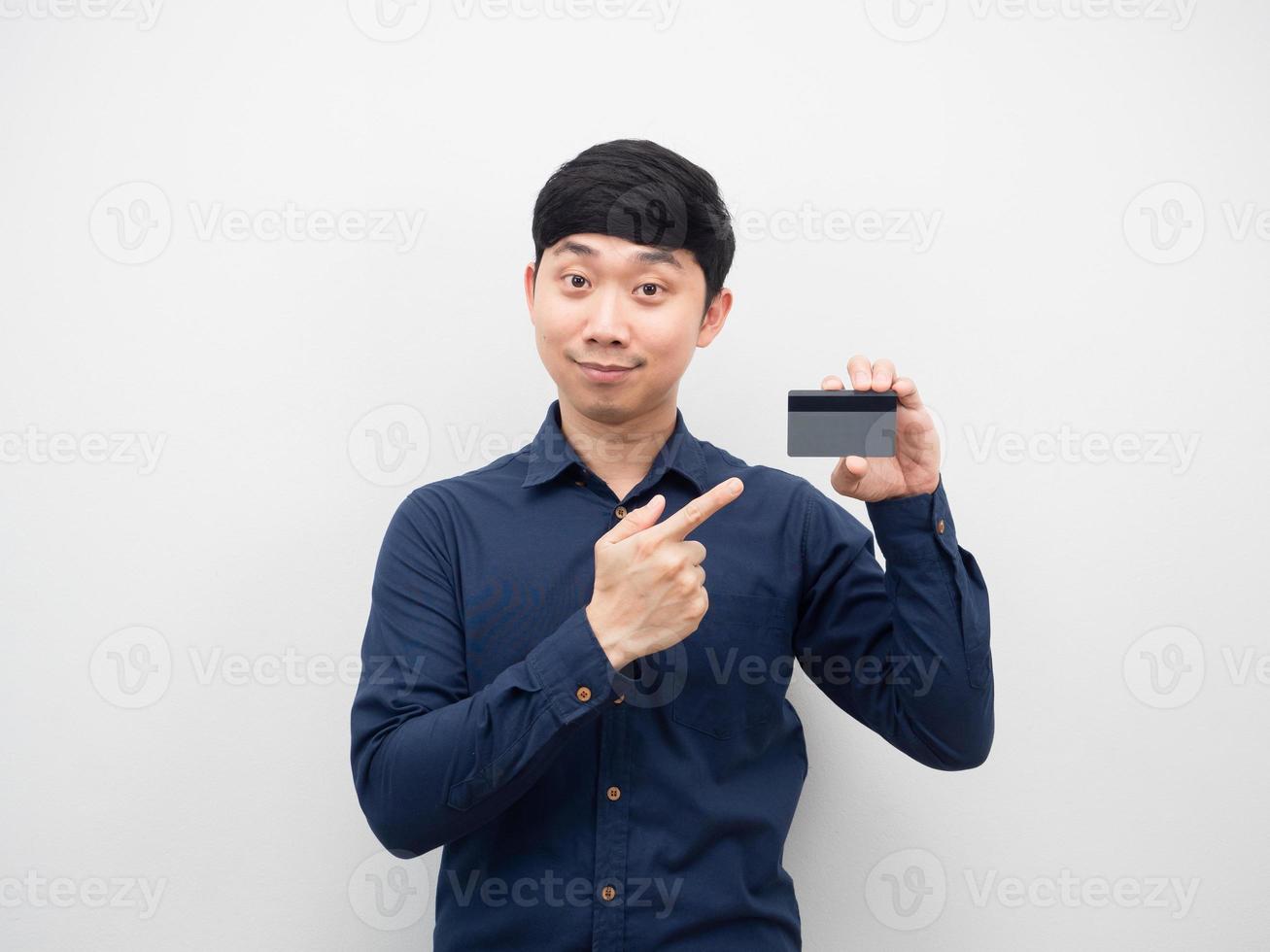 el hombre señala con el dedo la tarjeta de crédito en la mano foto