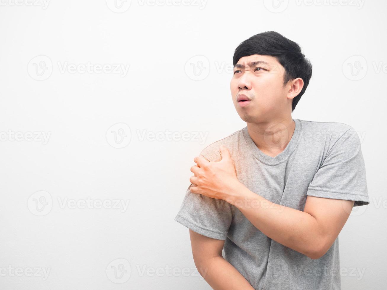 Asian man gesture hurt his shoulder looking at copy space photo