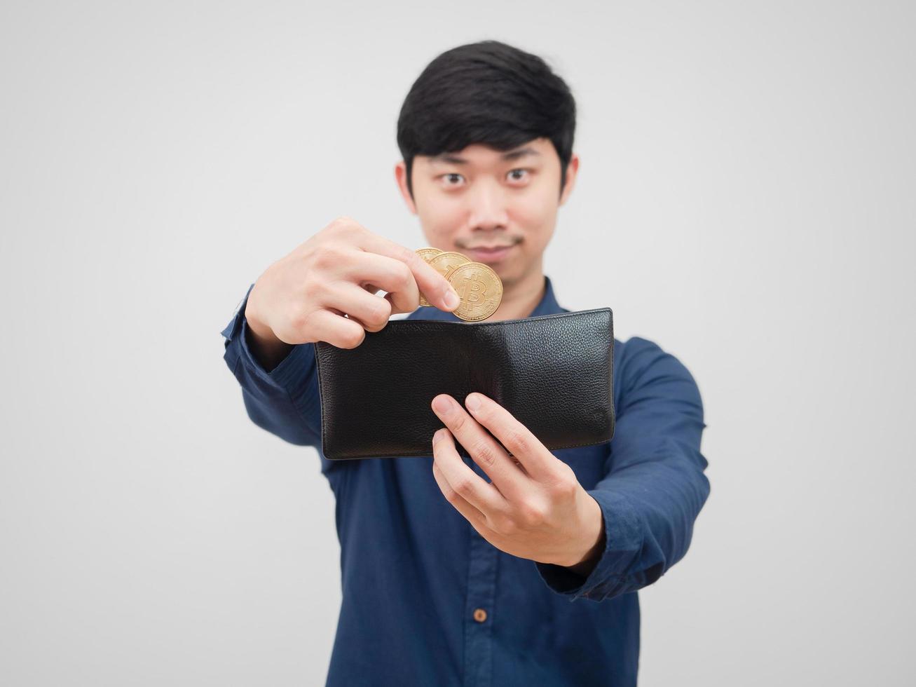 Closeup hand of man pick up bitcoin from his wallet with smile face white background photo