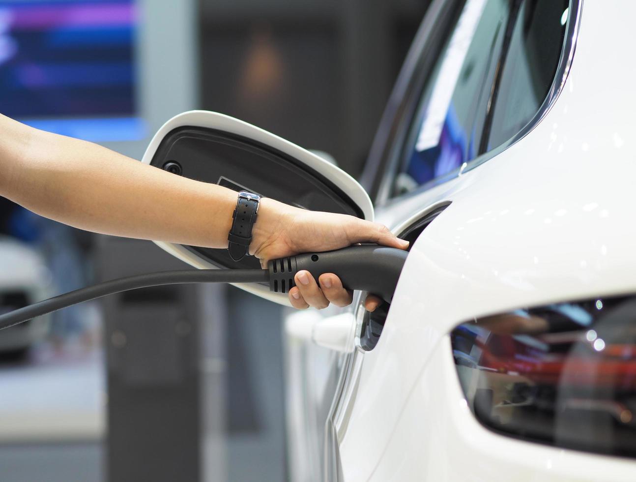 toma de mano del vehículo de carga eléctrica para recargar la batería del coche energía de energía limpia de color negro para el concepto futuro foto