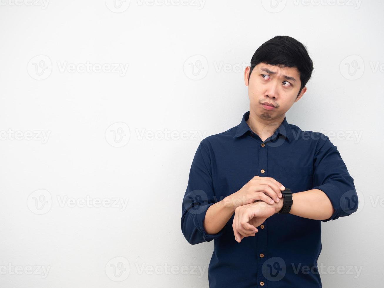 Man touch his watch and looking at copy space photo