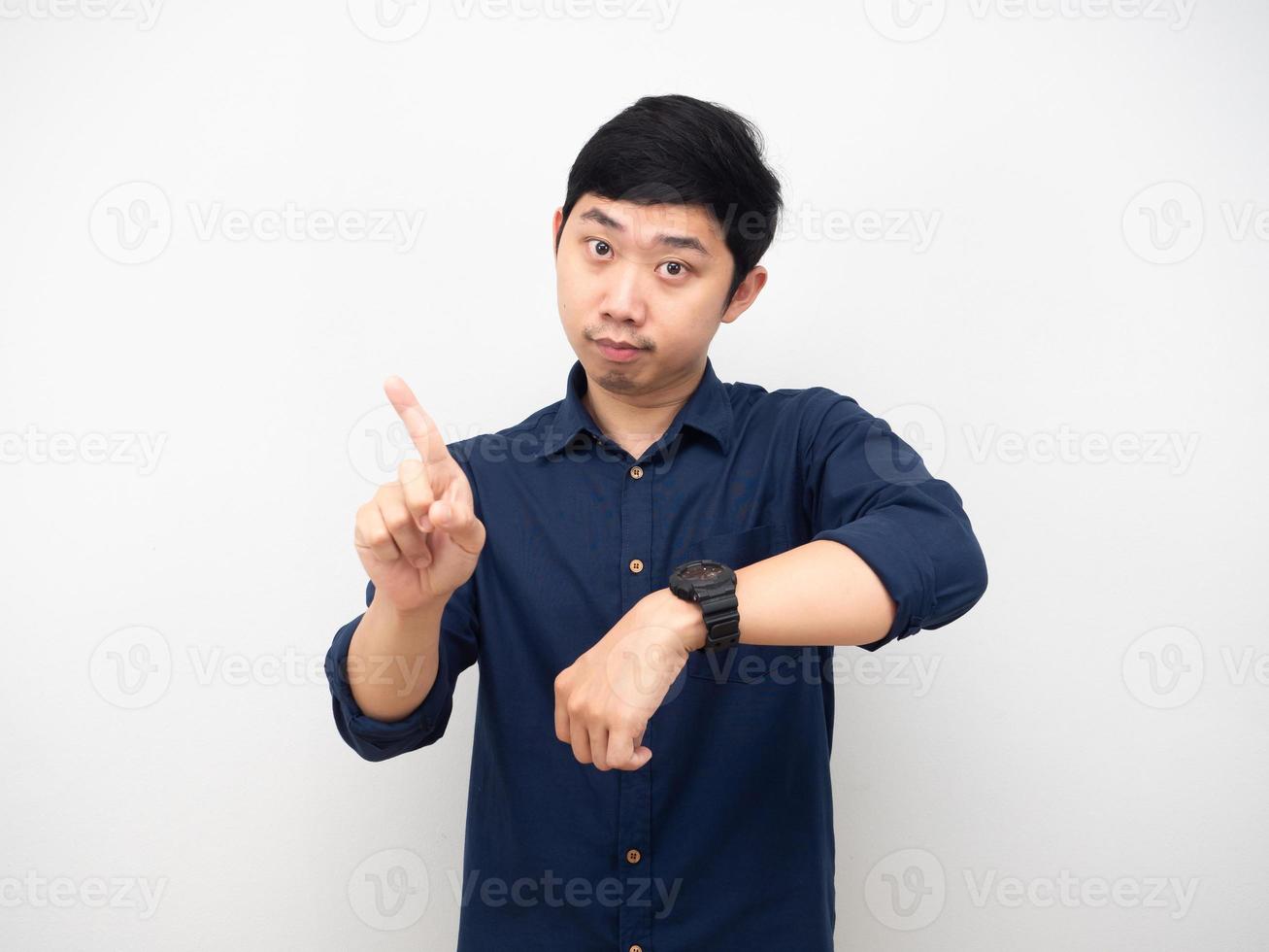 Asian man show his watch and swing his finger looking at you time late concept photo