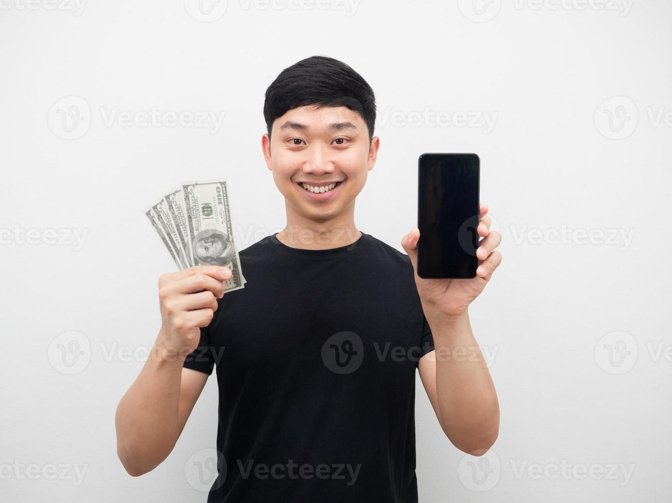 el hombre muestra el teléfono móvil y el dinero en la mano con una sonrisa feliz foto