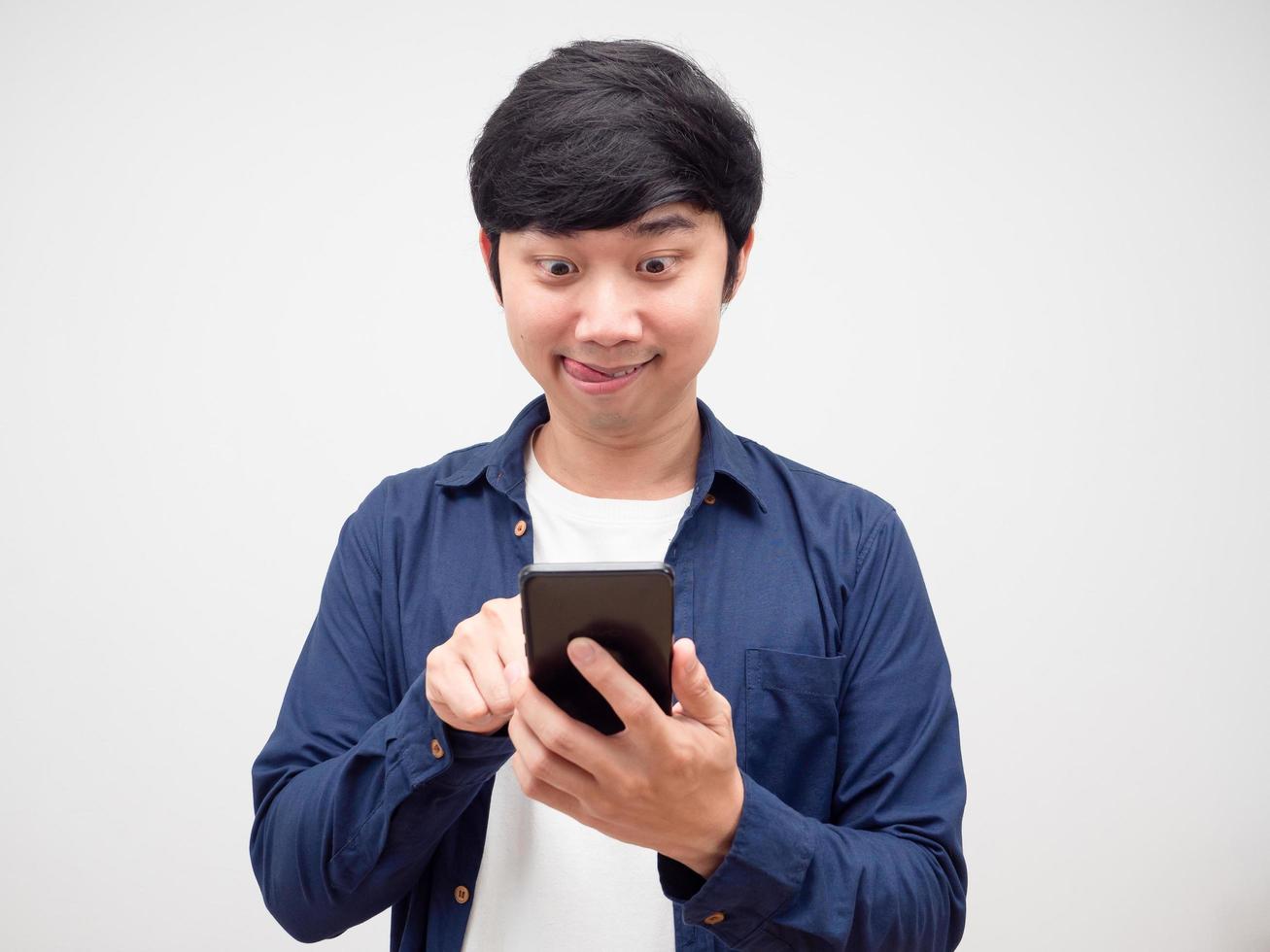 Young man feeling hungry and finding delivery food app in his cell phone  white background photo