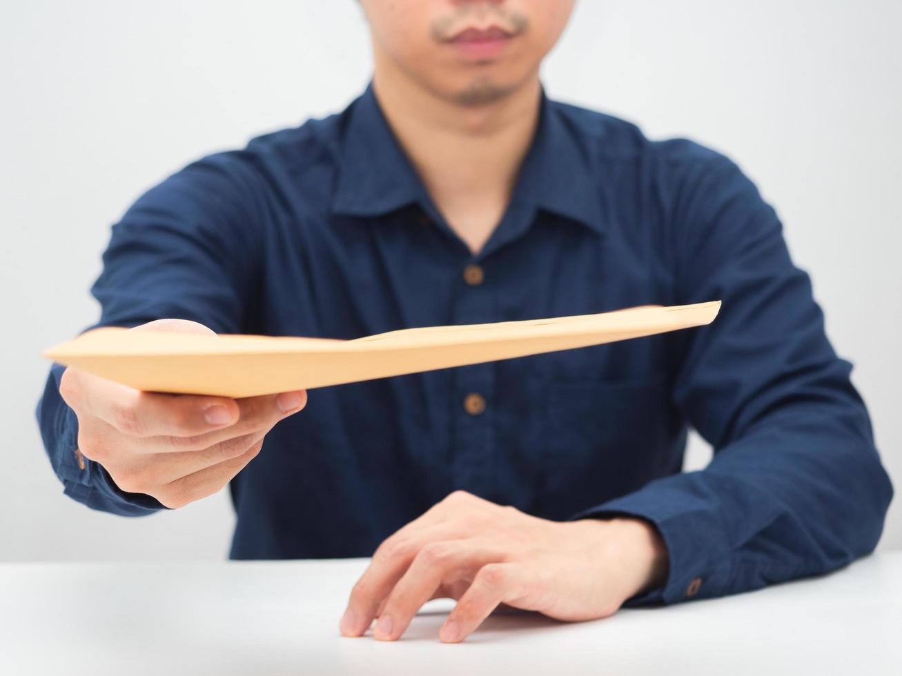 Closeup man giving document envelope at you on the desk,Businessman concept photo