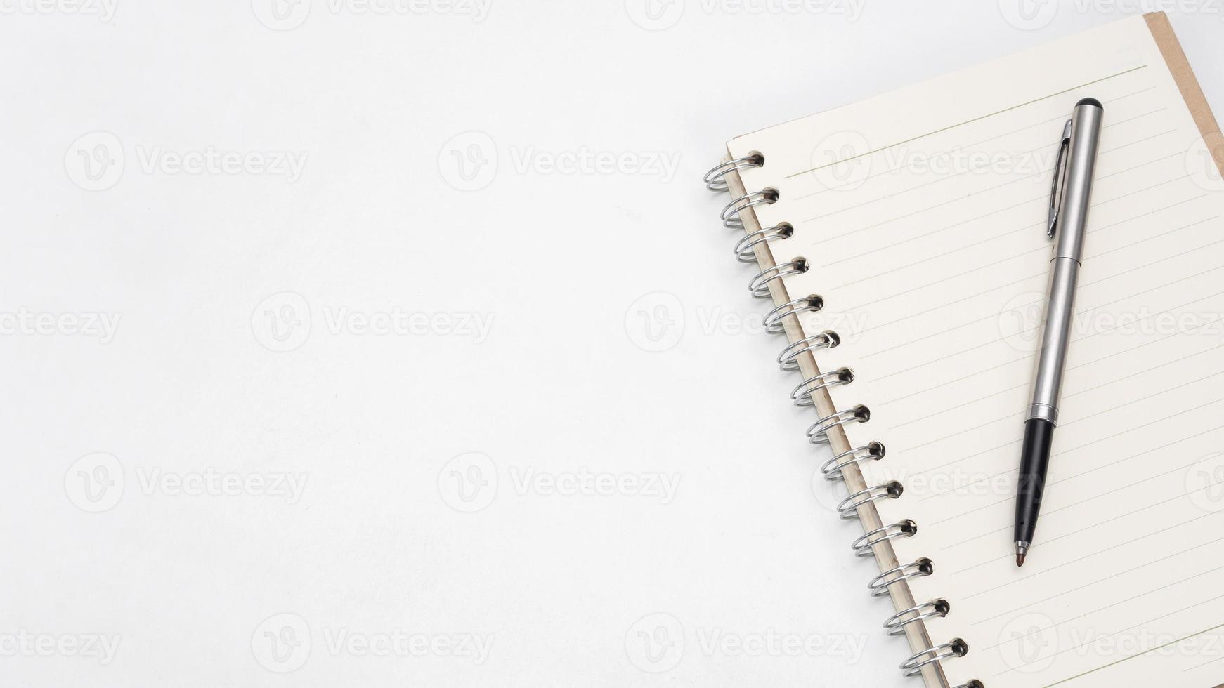 Silver pen and notebook blank page on the table top view copy space photo