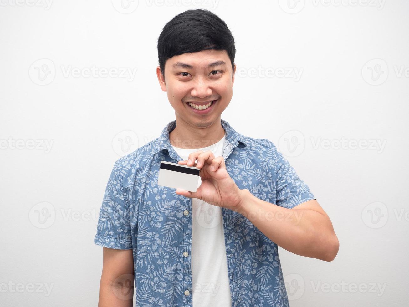 hombre feliz sonriendo y mostrando la tarjeta de crédito en la mano foto