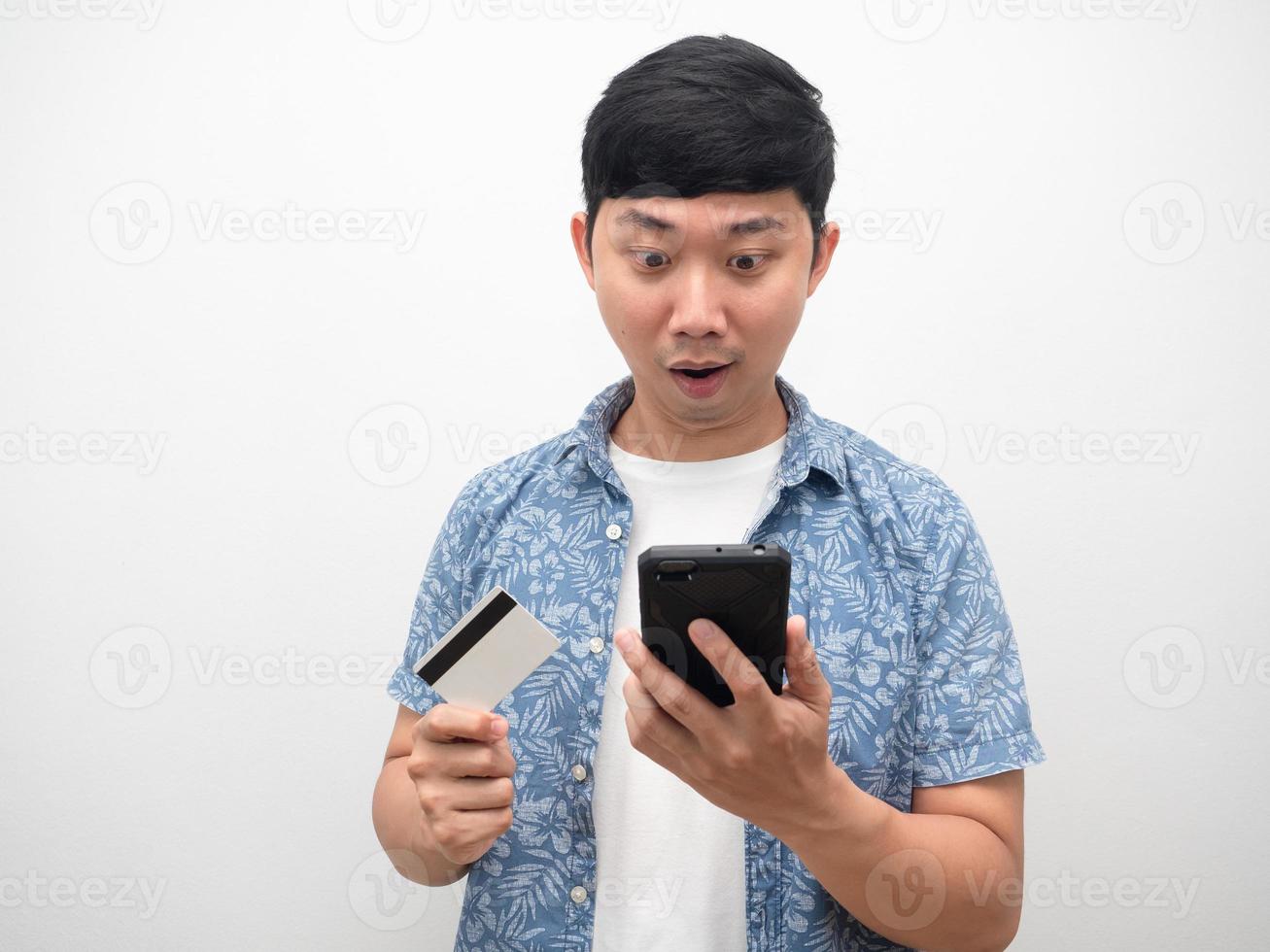 Asian man with credit card looking at mobile phone feel excted photo