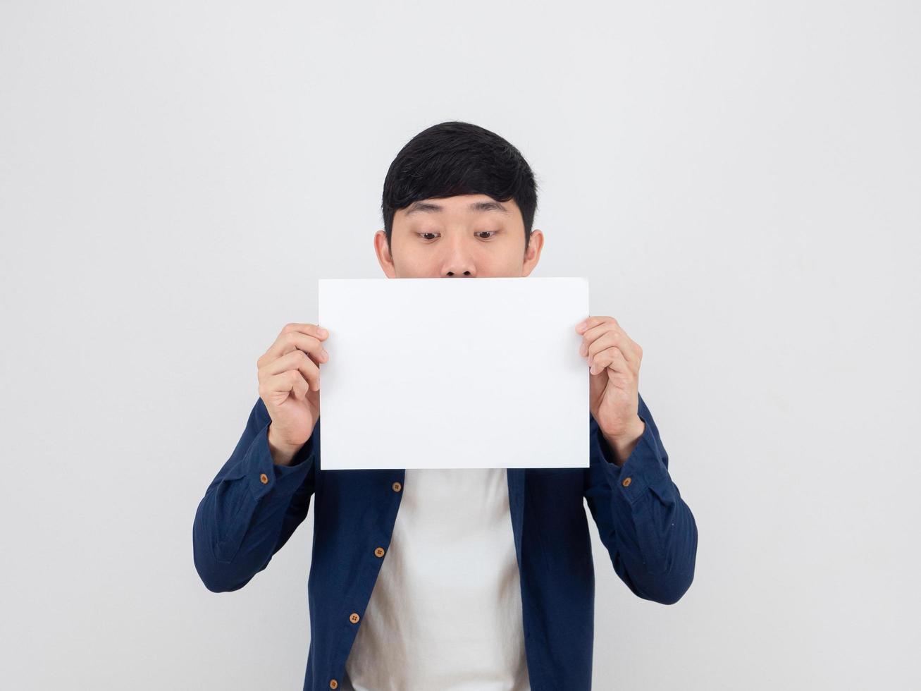 Man look at blank sheet in his hand and feel doubt about the paper on white isolated background photo