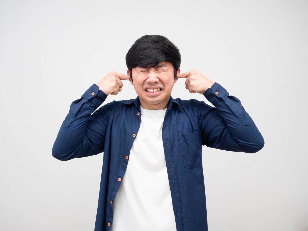 Asian man feeling afraid and plug finger at his ears dont want to heard every thing photo