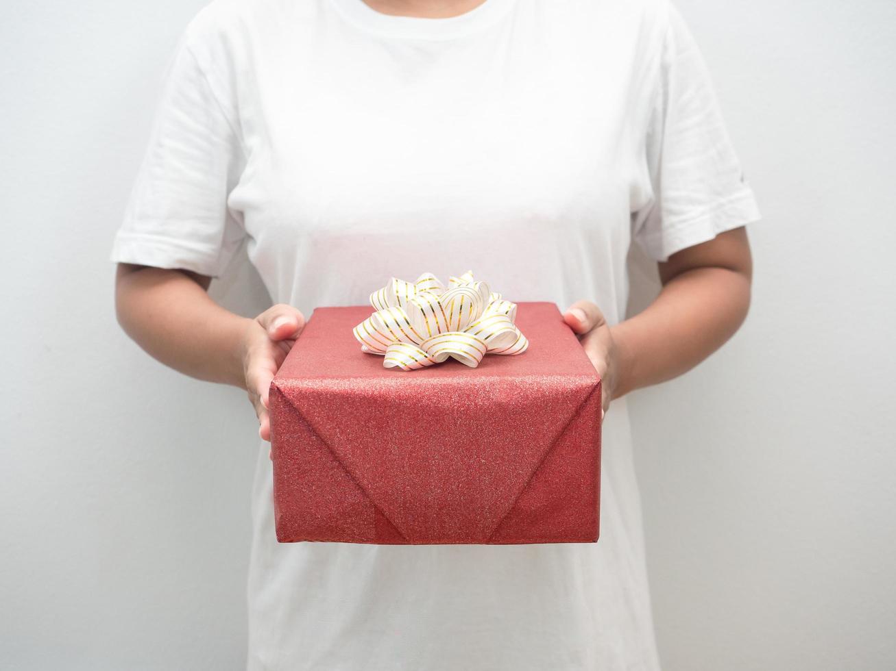 Crop shot woman hand holding red gift box whote background photo