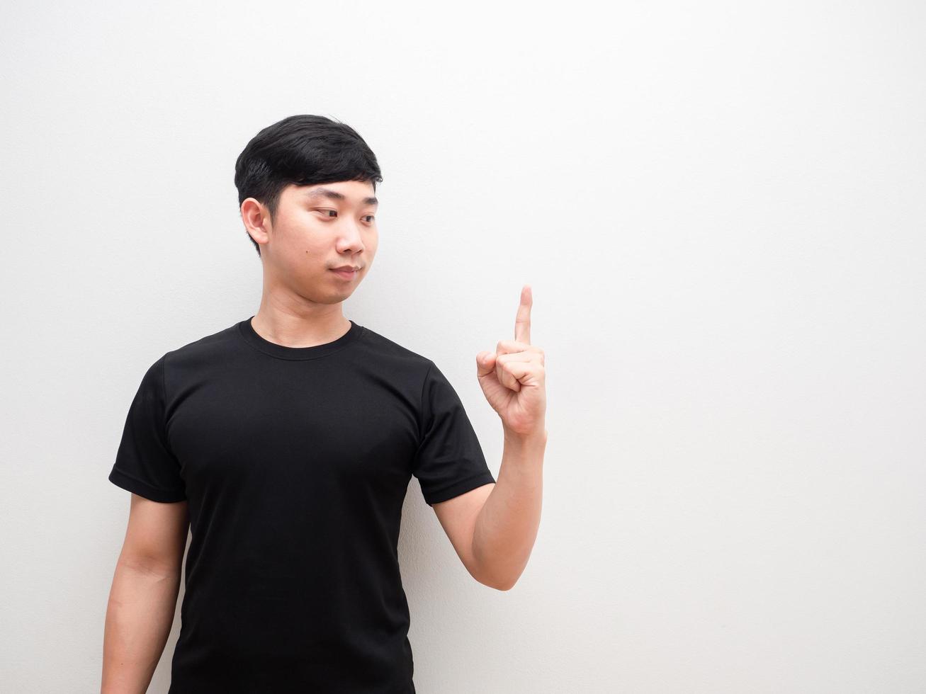 el hombre asiático mira el dedo de la mano izquierda hacia la cara confiada en el espacio de fondo blanco aislado foto
