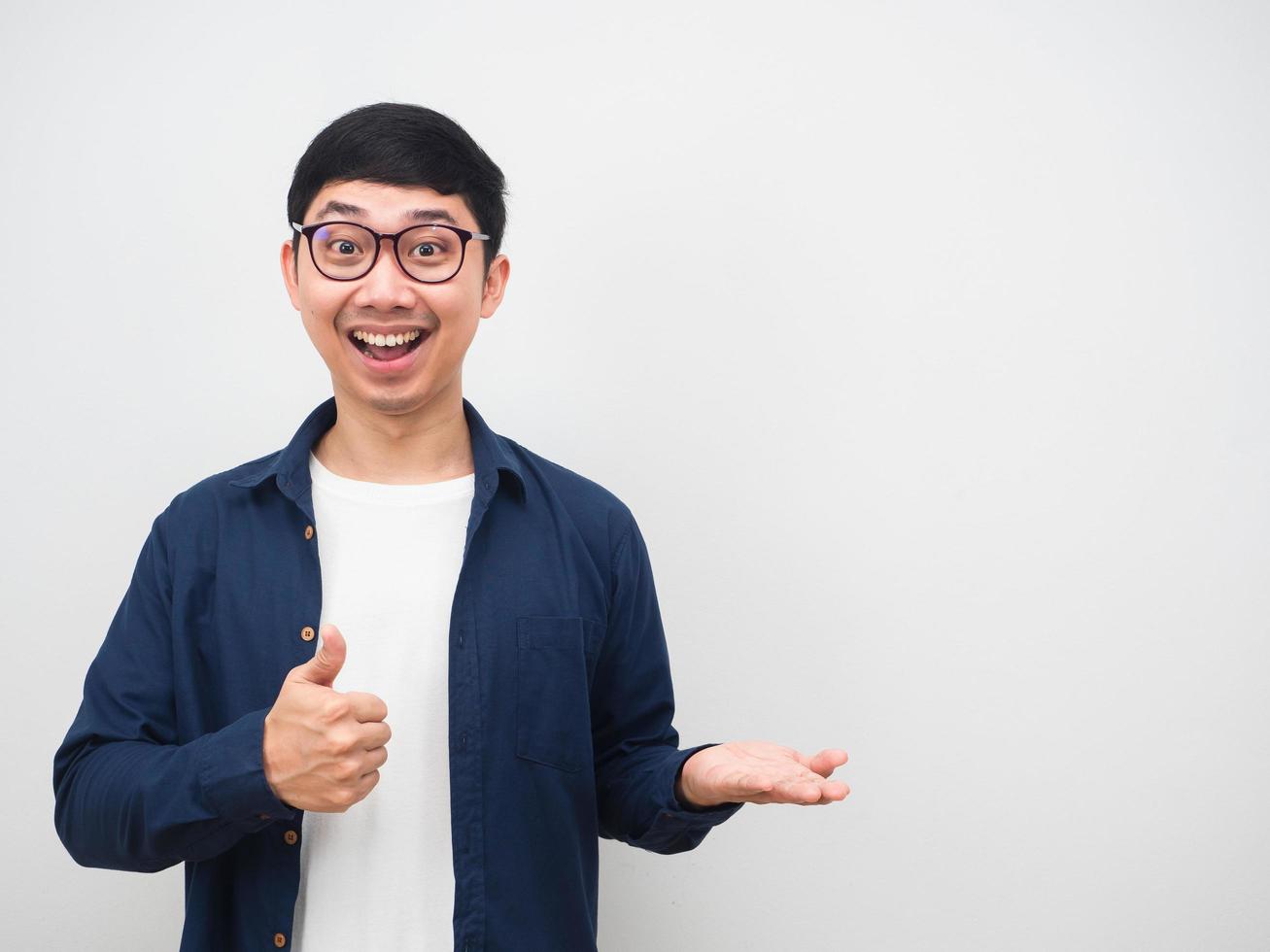 Man wearing glasses cheerful show thumb up and empty hand up for holding something white background photo