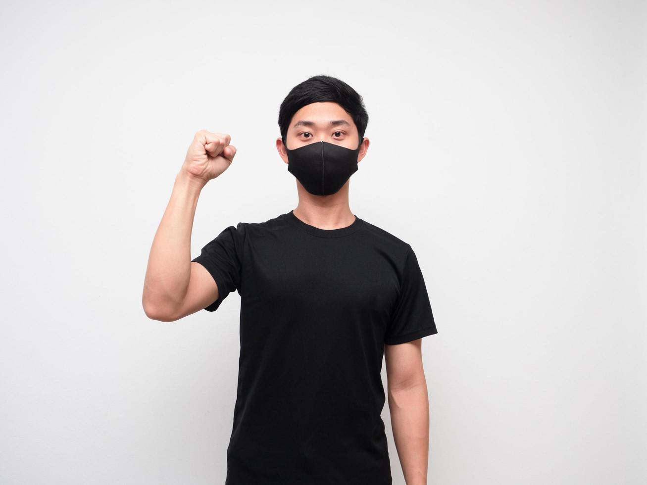 Cheerful man wearing protect mask show one fist up on white background photo